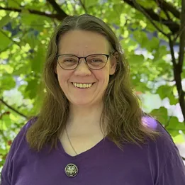 Lächelnde Frau mit dunklen Haaren.