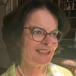 Lächelnde Frau mit einem orangefarbenen Ordner.