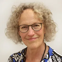 Lächelnder Mann mit Bart und dunklen Haaren.