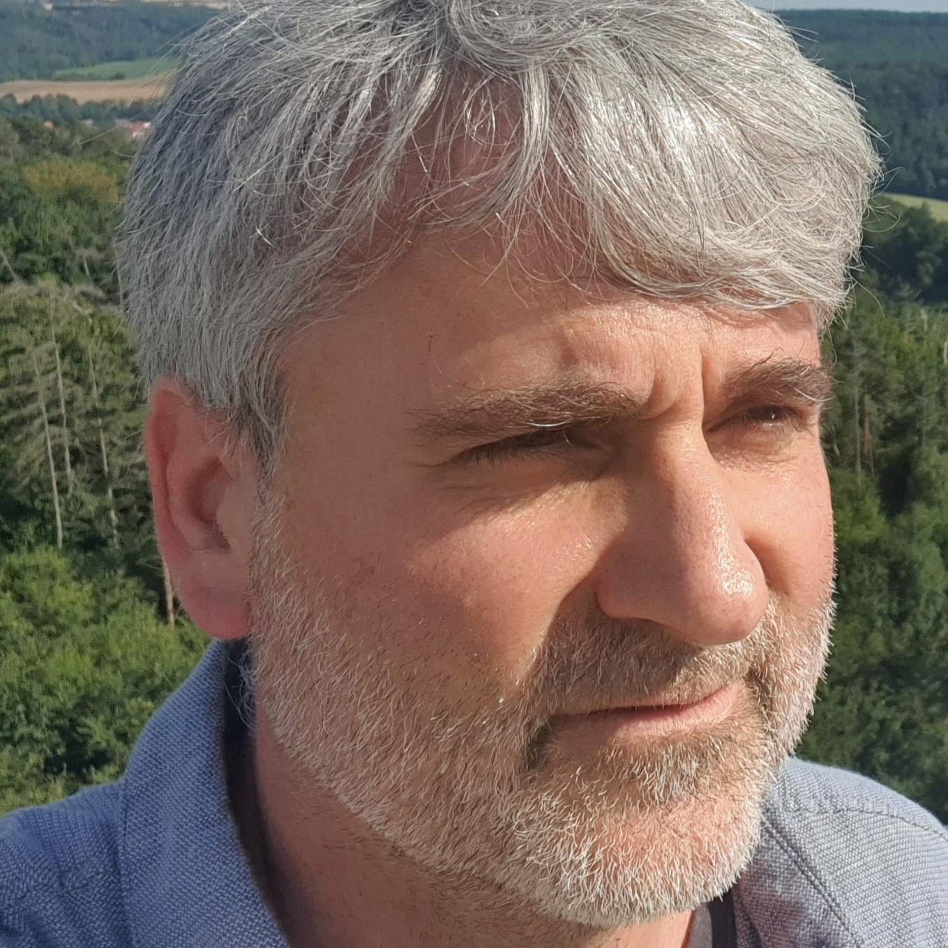 Lächelnder Mann mit Brille und Bart.