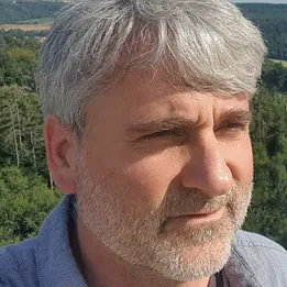 Lächelnder Mann mit Brille und Bart.